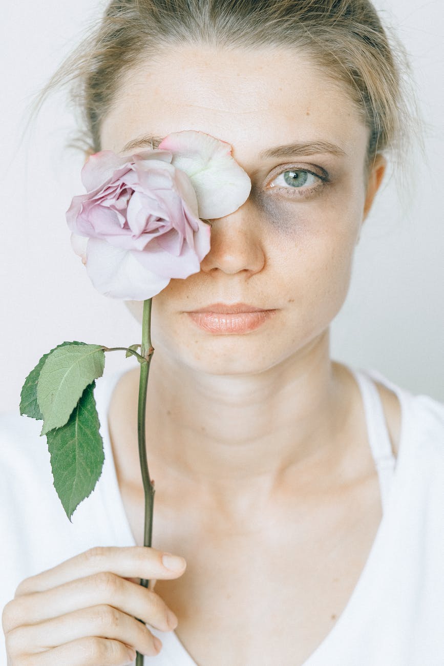 close up photo of woman holding a flower